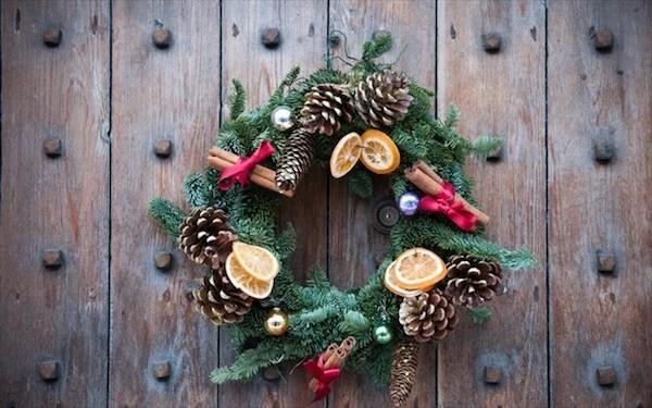 חרוטים ירוקים אשוחים תפוזים מקלות קינמון יוצרים זר דלת משלכם לחג המולד