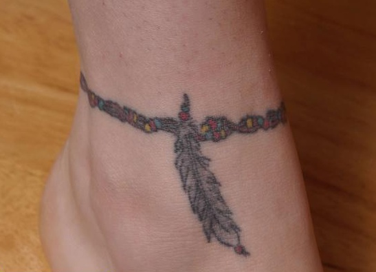 Tatuaje de pluma en el tobillo
