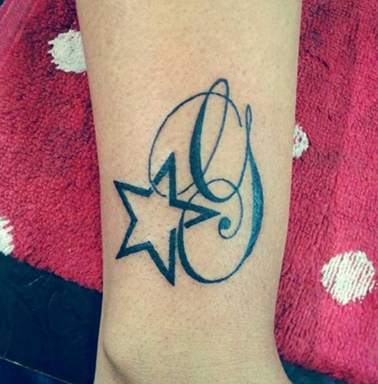 Incantevole tatuaggio con lettera G con una stella