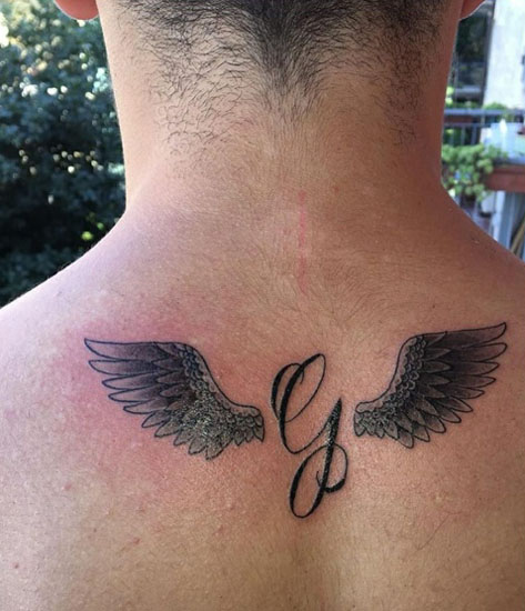Tatuaggio G corsivo con ali sul retro