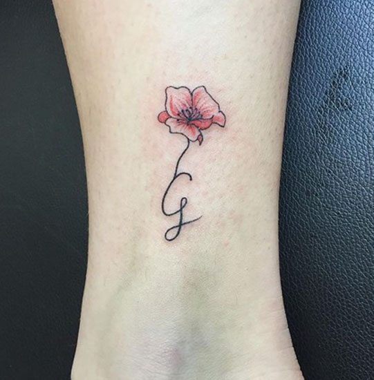 Delizioso disegno floreale del tatuaggio della lettera G