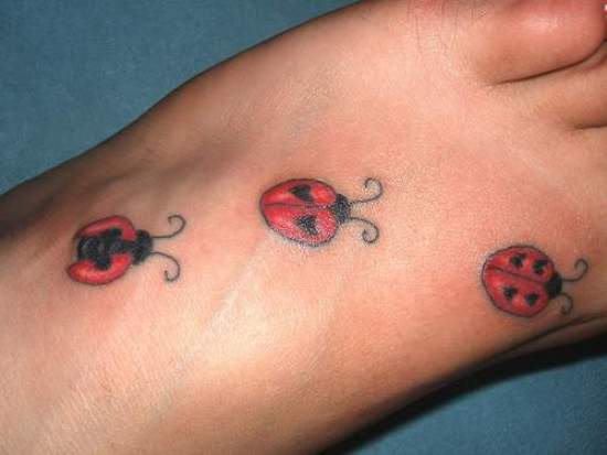 Tatuaje de tres mariquitas en el pie