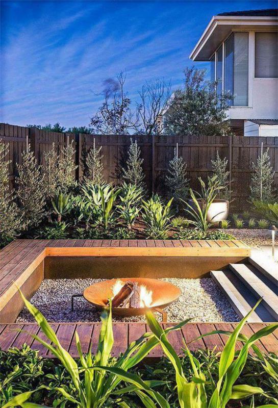 פינת ישיבה שקועה בחוץ הגנה על פרטיות גדר עץ הרבה צמחים ירוקים עיצוב יפה על משטח מרובע