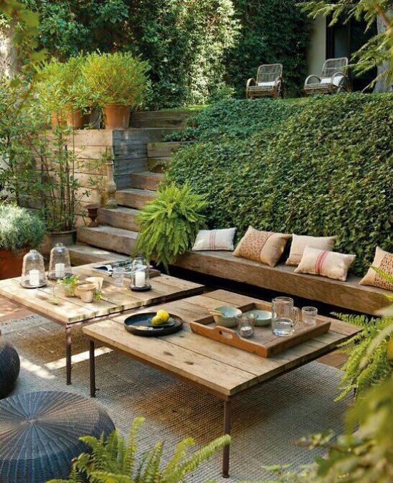 מקומות ישיבה בחוץ שקועים כמה צעדים במורד גן עדן ירוק ספסלי עץ שולחנות עץ צמחים ירוקים