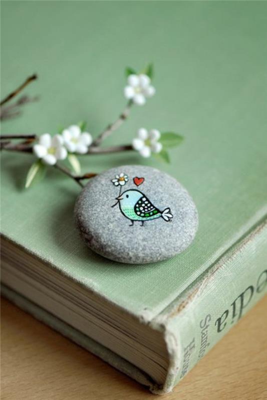 ציור ציפור עם פרח ולב על אבן